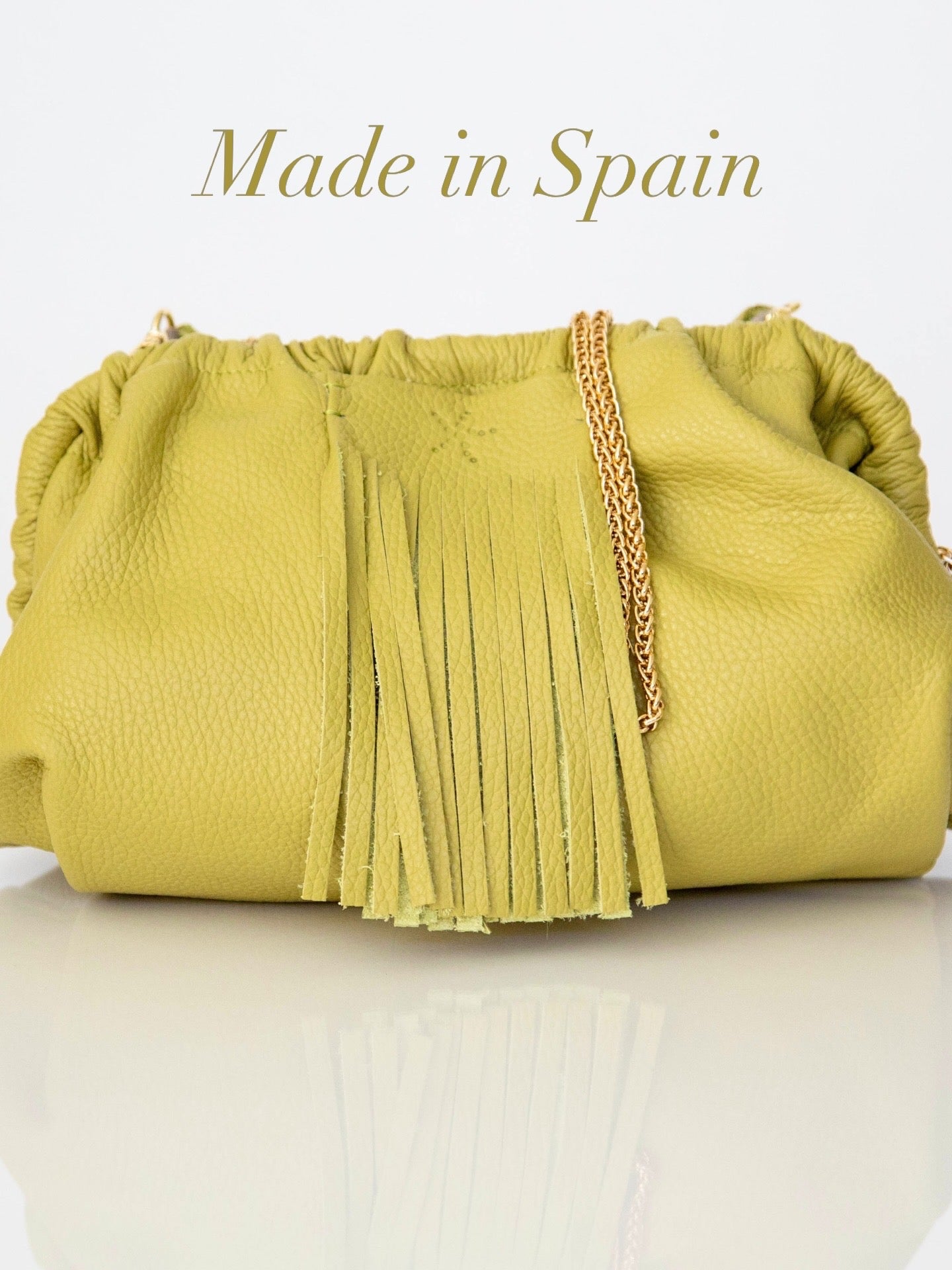Natalia - Full Grain Leather Clutch Bag - Vinaigrette with fringes and a chain detail on a white background, labeled 'Made in Spain'.